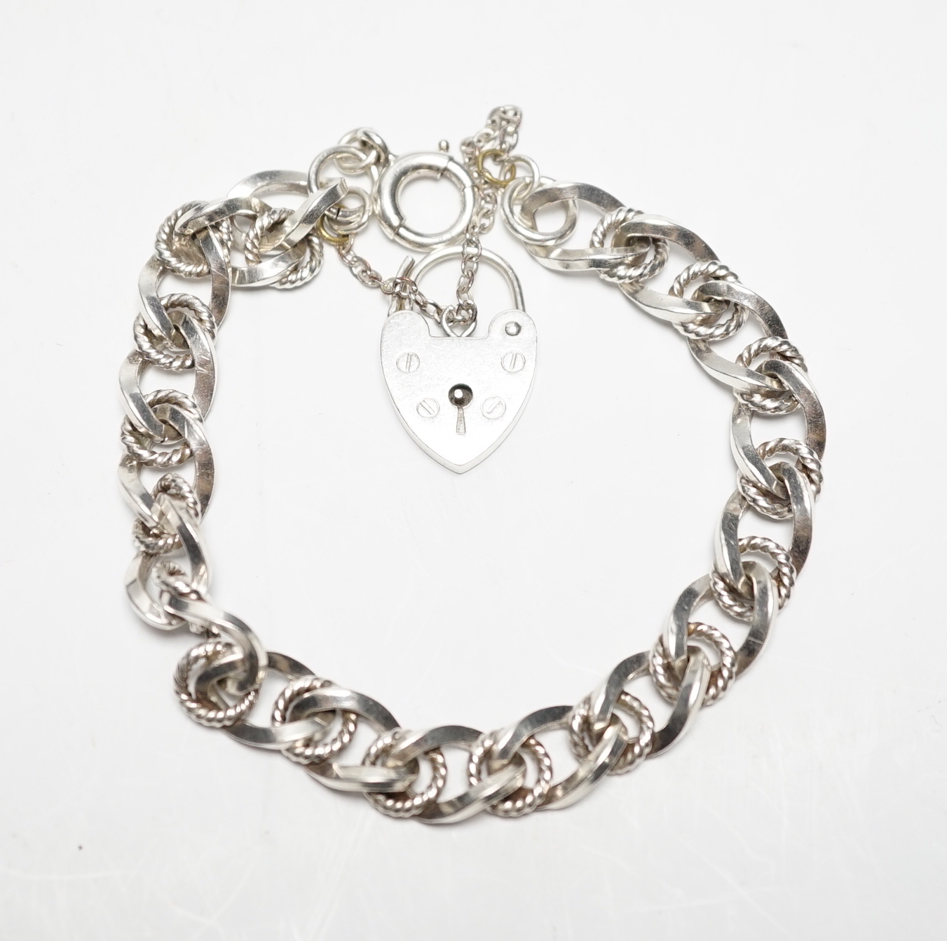 A modern silver curb and rope twist link bracelet, with heart shaped padlock clasp, 18cm.